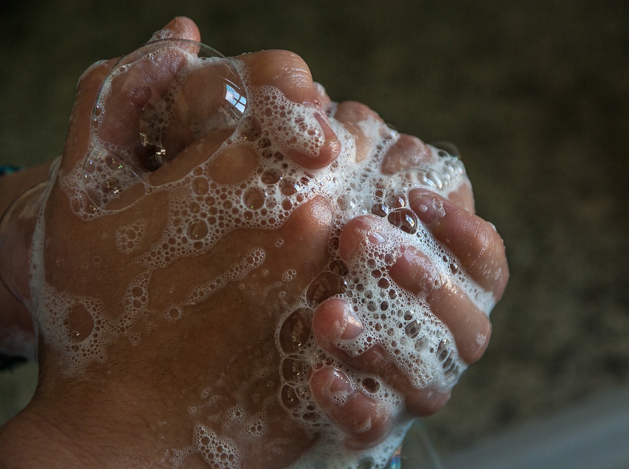 Zwei Hände greifen ineinander und schäumen Seife auf.